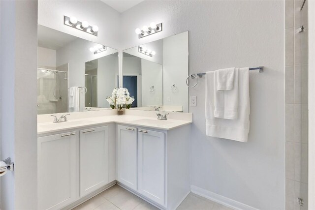 240 Olympic Park Dr, Kyle, TX 78640 - bathroom with double vanity, a sink, a stall shower, and tile patterned floors