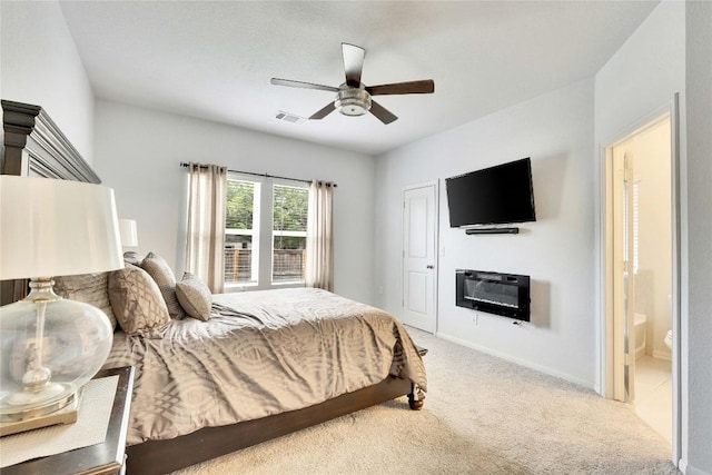 240 Olympic Park Dr, Kyle, TX 78640 - carpeted bedroom with baseboards, a ceiling fan, ensuite bath, and visible vents