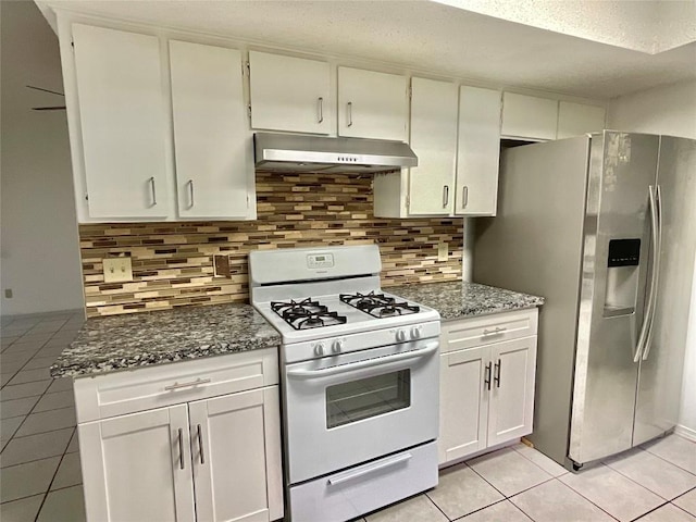 10810 Calcite Trl, Austin, TX 78750 - kitchen with light tile patterned flooring, stainless steel fridge, dark stone counters, white gas stove, and under cabinet range hood