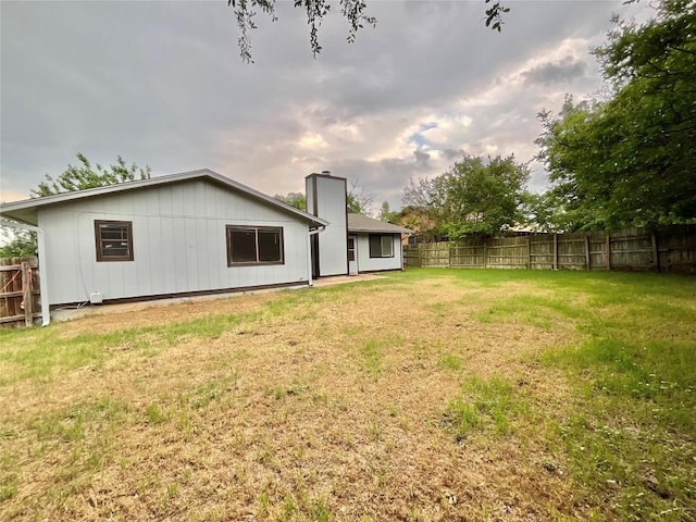 10810 Calcite Trl, Austin, TX 78750 - back of house with a fenced backyard, a chimney, and a lawn