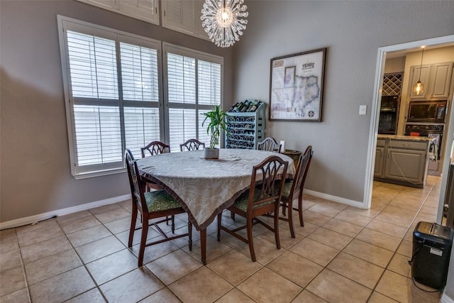 dining room with baseboards, a notable chandelier, a healthy amount of sunlight, and light tile patterned floors