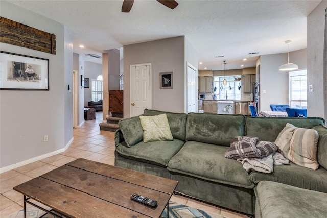 living room with light tile patterned flooring, ceiling fan, recessed lighting, and baseboards