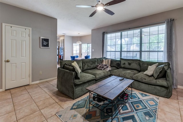 living room featuring baseboards, ceiling fan, and light tile patterned flooring