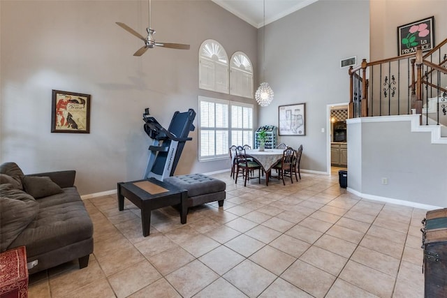living room with light tile patterned floors, crown molding, a high ceiling, and visible vents