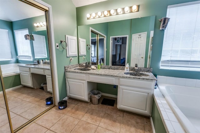 bathroom featuring double vanity, tile patterned floors, a wealth of natural light, and a garden tub