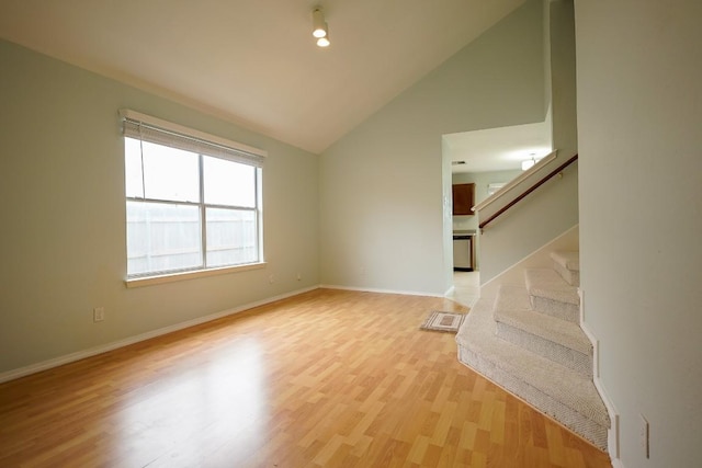 1712 Southwestern Dr, Round Rock, TX 78664 - unfurnished living room with stairs, light wood-style floors, and vaulted ceiling
