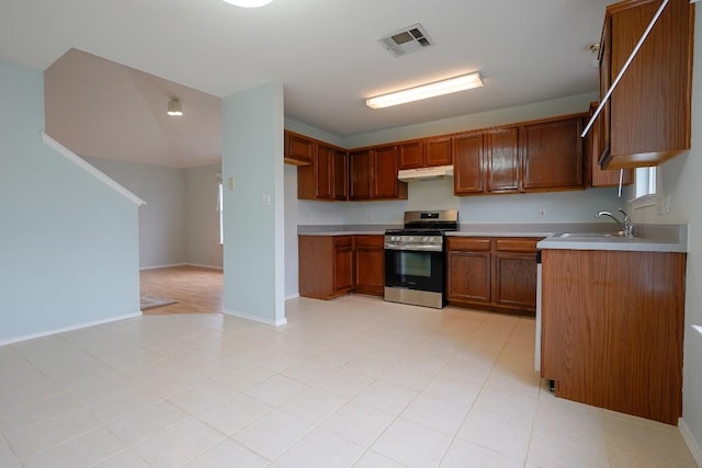 1712 Southwestern Dr, Round Rock, TX 78664 - kitchen featuring stainless steel gas range, light countertops, brown cabinetry, and under cabinet range hood