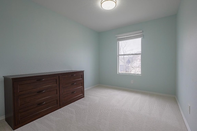 unfurnished bedroom with baseboards and light colored carpet