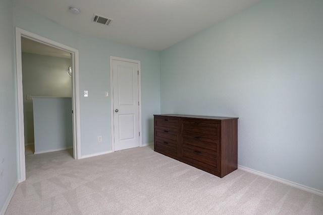 unfurnished bedroom with baseboards, carpet, and visible vents