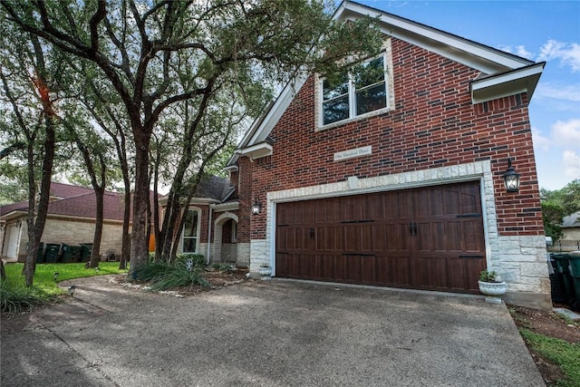 103 Sierra Ridge Dr, San Marcos, TX 78666 - view of property exterior featuring a garage, stone siding, driveway, and brick siding