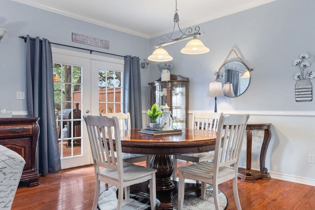 dining space with french doors, baseboards, crown molding, and wood finished floors