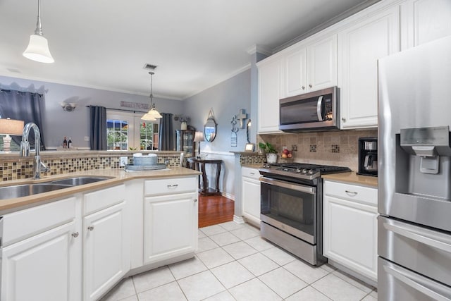 kitchen featuring light tile patterned flooring, a sink, stainless steel appliances, tasteful backsplash, and visible vents