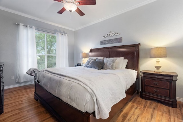 bedroom featuring crown molding, a ceiling fan, baseboards, and wood finished floors