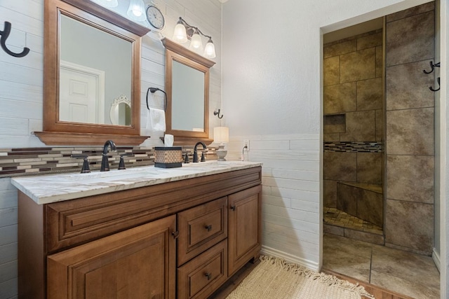 full bathroom with a sink, tile walls, walk in shower, and double vanity