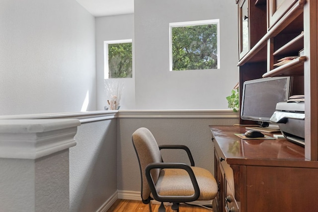 home office with baseboards, a textured wall, and wood finished floors
