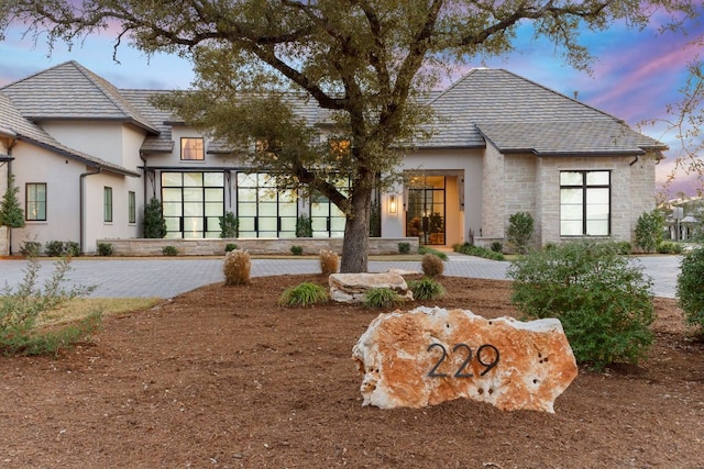229 Tiffanie Way, Austin, TX 78737 - back of property at dusk featuring stucco siding and stone siding