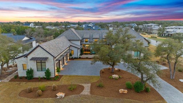 229 Tiffanie Way, Austin, TX 78737 - view of front facade featuring curved driveway, a residential view, an attached garage, and stone siding