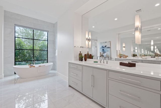 229 Tiffanie Way, Austin, TX 78737 - bathroom with visible vents, a freestanding bath, vanity, marble finish floor, and recessed lighting