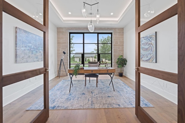 229 Tiffanie Way, Austin, TX 78737 - home office with baseboards, a tray ceiling, visible vents, and wood finished floors