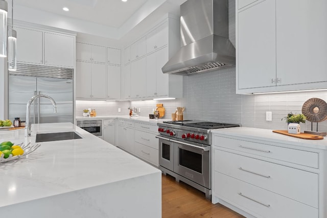 229 Tiffanie Way, Austin, TX 78737 - kitchen with decorative backsplash, wall chimney exhaust hood, white cabinets, and premium appliances