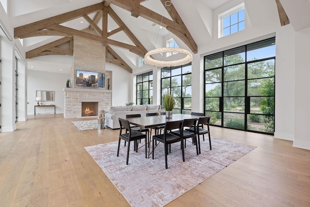229 Tiffanie Way, Austin, TX 78737 - dining area with beamed ceiling, high vaulted ceiling, a stone fireplace, and light wood finished floors