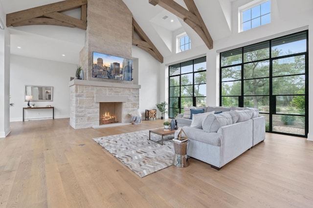 229 Tiffanie Way, Austin, TX 78737 - living area with high vaulted ceiling, a stone fireplace, wood finished floors, and a healthy amount of sunlight