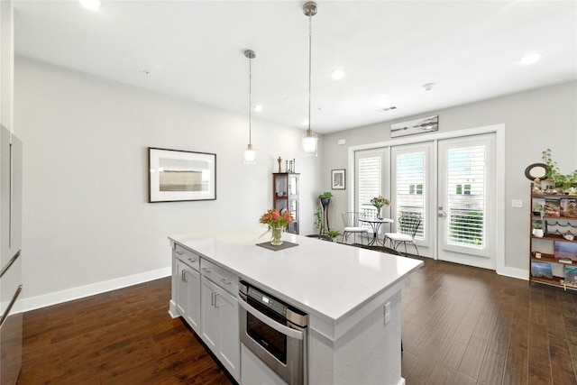 kitchen with oven, baseboards, recessed lighting, light countertops, and hanging light fixtures