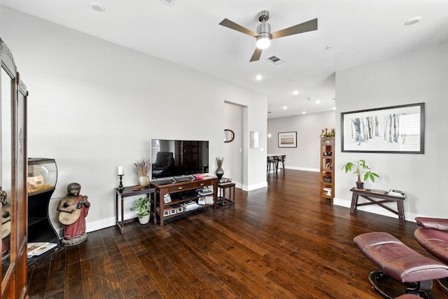 living area featuring visible vents, a ceiling fan, baseboards, and hardwood / wood-style floors