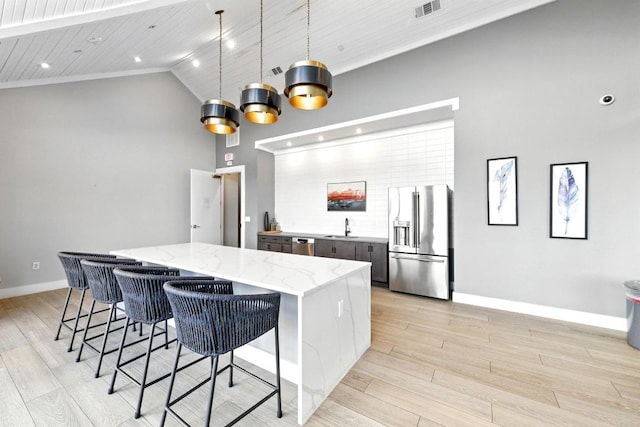 kitchen with visible vents, a sink, baseboards, stainless steel appliances, and light wood-style flooring