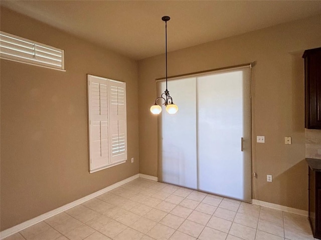 196 Whispering Wind Dr, Georgetown, TX 78633 - unfurnished dining area with light tile patterned floors, a chandelier, and baseboards