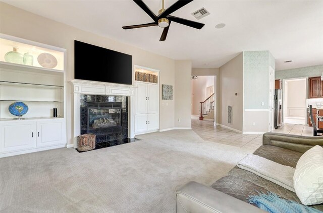 10768 Bramblecrest Dr, Austin, TX 78726 - living area featuring ceiling fan, stairs, light carpet, a premium fireplace, and light tile patterned floors