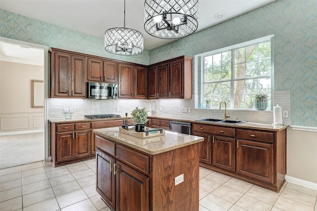 10768 Bramblecrest Dr, Austin, TX 78726 - kitchen with appliances with stainless steel finishes, a chandelier, wallpapered walls, a kitchen island, and light stone counters