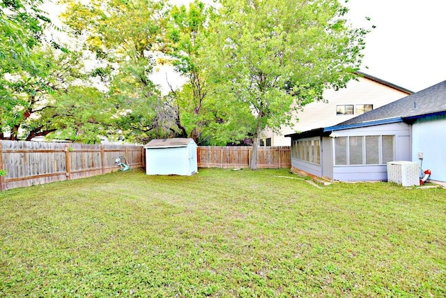 1411 Baffin Cv, Round Rock, TX 78664 - view of yard with an outdoor structure, cooling unit, a fenced backyard, a sunroom, and a storage unit