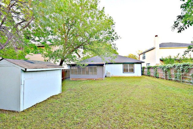 1411 Baffin Cv, Round Rock, TX 78664 - rear view of house featuring a sunroom, a fenced backyard, a yard, and a storage shed