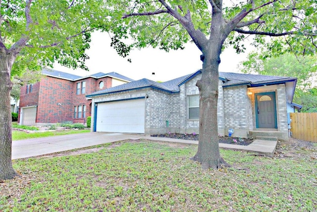 1411 Baffin Cv, Round Rock, TX 78664 - view of front of house with fence, an attached garage, concrete driveway, and brick siding