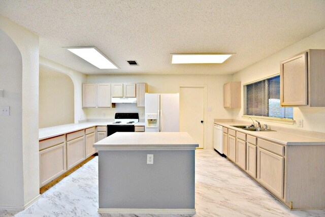 1411 Baffin Cv, Round Rock, TX 78664 - kitchen with a sink, white appliances, light countertops, a center island, and under cabinet range hood