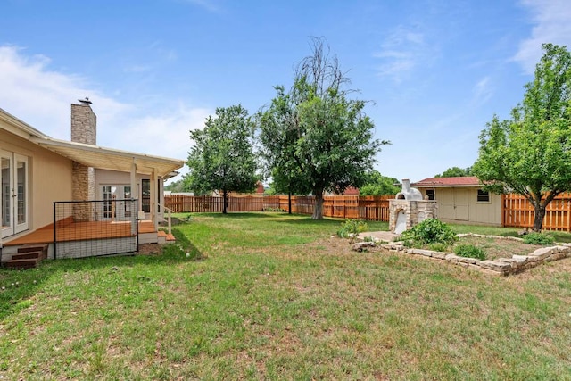 view of yard featuring a fenced backyard, a deck, and french doors