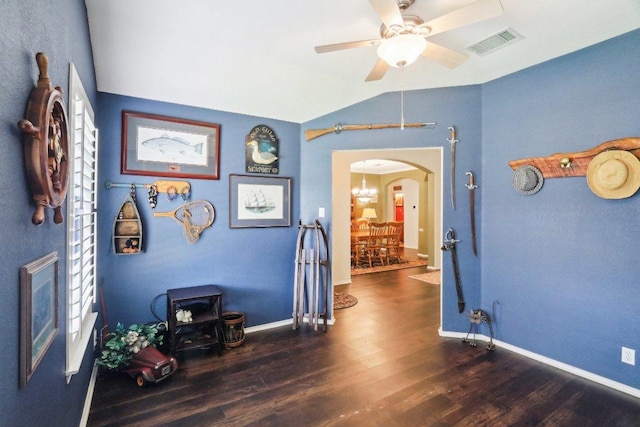 corridor with visible vents, arched walkways, wood finished floors, and vaulted ceiling