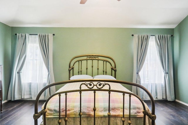 bedroom featuring baseboards and dark wood-type flooring