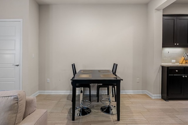 dining area with baseboards and light wood finished floors