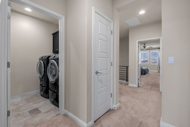 corridor featuring independent washer and dryer, baseboards, visible vents, and light carpet