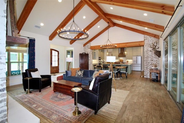 living room featuring visible vents, beamed ceiling, high vaulted ceiling, light wood finished floors, and a notable chandelier