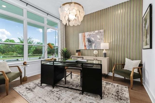 home office featuring baseboards, a wealth of natural light, wood finished floors, and a notable chandelier