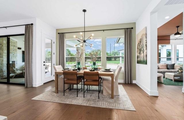 dining area featuring baseboards, wood finished floors, visible vents, and an inviting chandelier