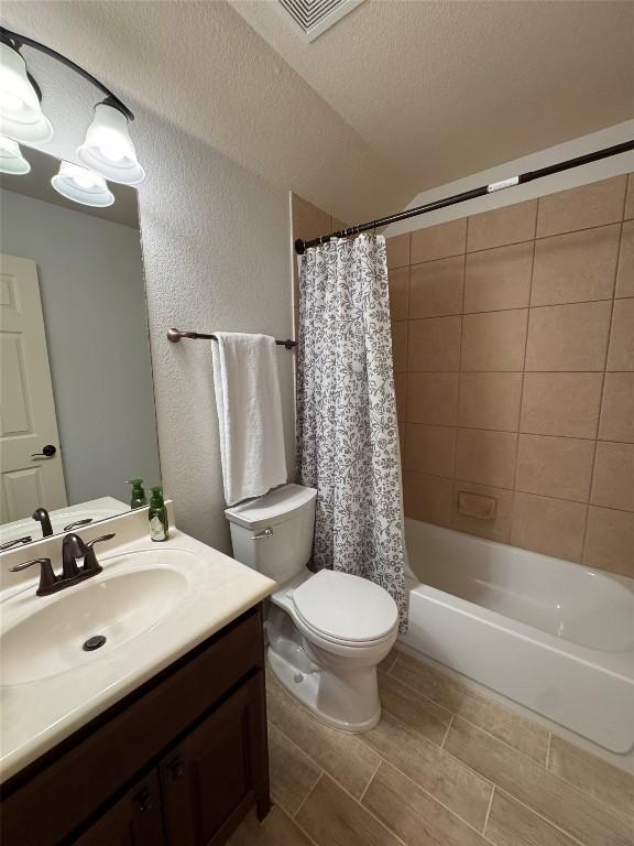 462 Shelf Rock, Driftwood, TX 78619 - bathroom with vanity, toilet, a textured wall, shower / tub combo with curtain, and a textured ceiling