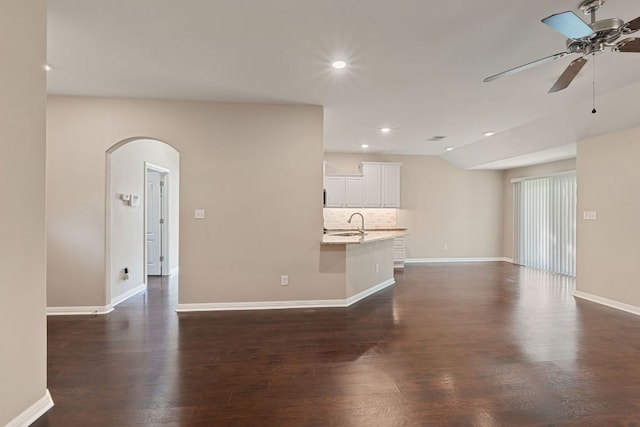 425 Valley Oaks Loop, Georgetown, TX 78626 - unfurnished living room with a ceiling fan, arched walkways, dark wood-type flooring, lofted ceiling, and baseboards