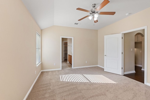 425 Valley Oaks Loop, Georgetown, TX 78626 - unfurnished bedroom with carpet floors, arched walkways, baseboards, vaulted ceiling, and ensuite bathroom