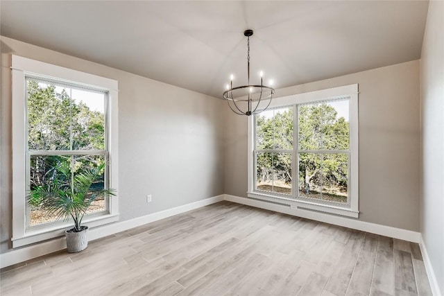 2502 Truman Dr, Lago Vista, TX 78645 - unfurnished dining area featuring baseboards, light wood-style flooring, and a notable chandelier