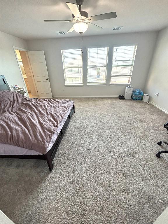 bedroom with visible vents, carpet floors, and multiple windows