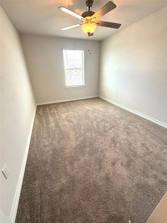 empty room featuring baseboards, a ceiling fan, and carpet flooring